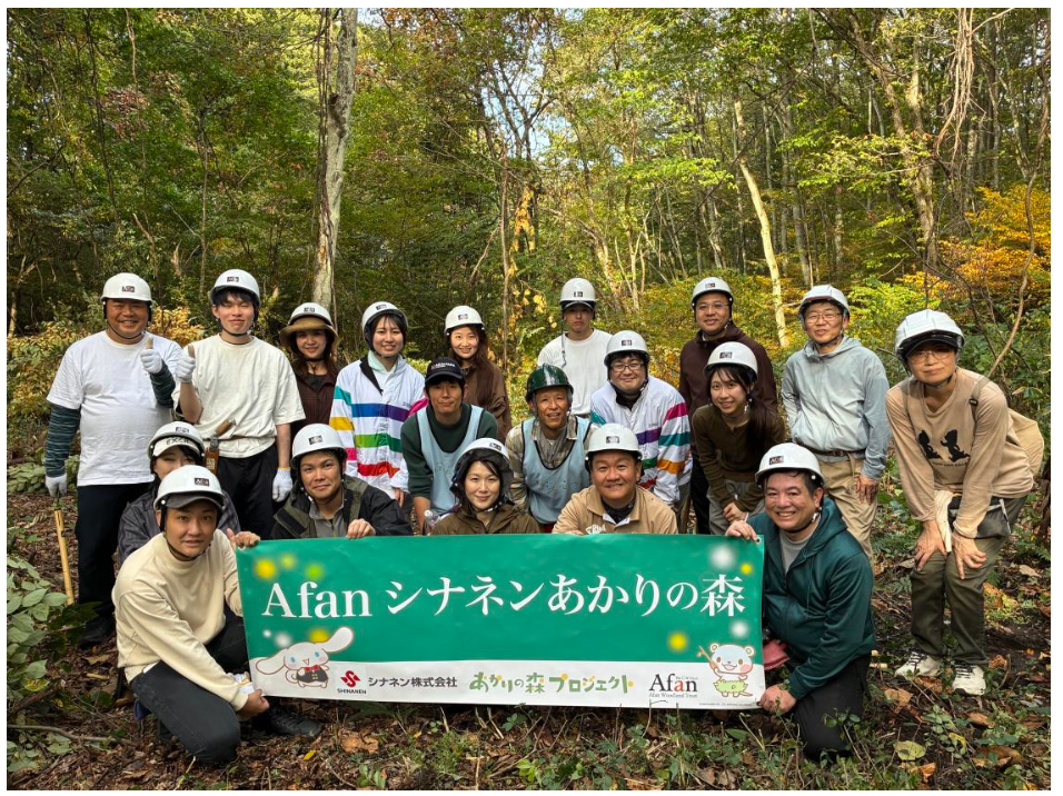 発表に添付された森林整備活動の集合写真。「Afan シナネンあかりの森」の横断幕が見えます。館内の特別展示を撮影した写真ではありません。